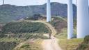 Cyclists among windmills on the route to San Martín de Luiña