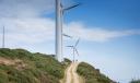 Cyclists on the route to San Martin de Luiña crossing a wind farm