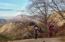 Cyclists climbing to the Mirador de Següencu with mountains in the background