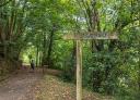 Hikers walking along the Senda Verde de Lloreo next to a sign for the Frechura site.