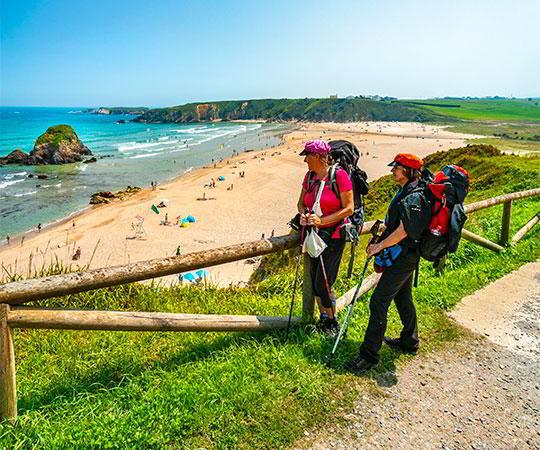 Photo of pilgrims at Penarronda Beach on the Camino de Santiago de la Costa or Camino de Santiago del Norte. Located between the municipalities of Castropol and Tapia de Casariego.