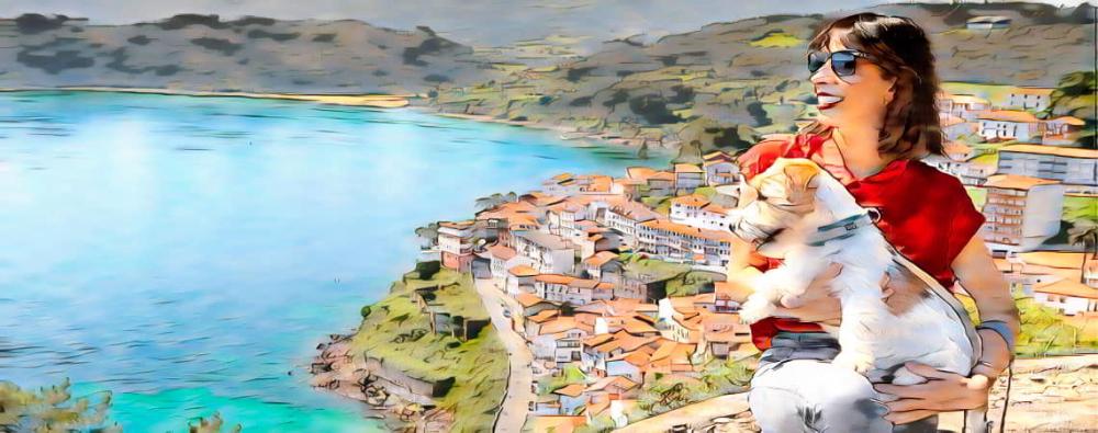 Young woman enjoying nature with her harnessed dog in a wooded setting.