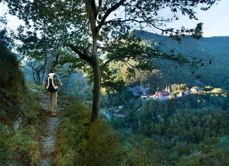 Photo of the Sanctuary of Covadonga from the Pilgrimage Route. In the foreground pilgrim on the route.