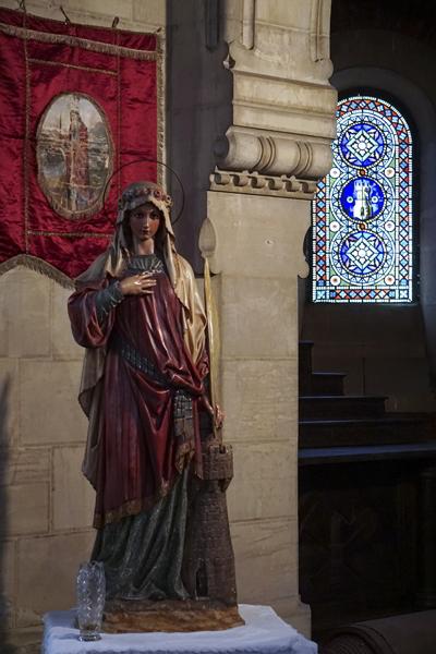 Image and stained glass window of Santa Bárbara in the church of the Mining Village of Bustiello.
