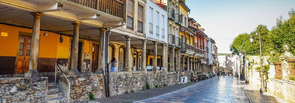 Image of Calle Galiana in Avilés with its well-known arcades in the foreground.