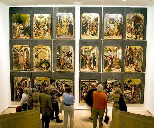 Image of people inside the Museum of Fine Arts of Asturias looking at paintings.