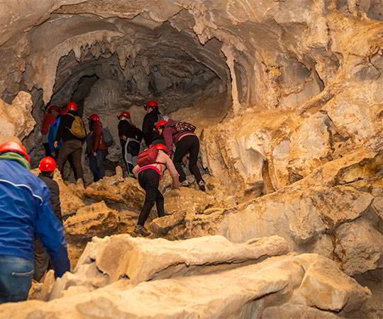 Image of a group of people entering Cueva Huerta in the municipality of Teverga.