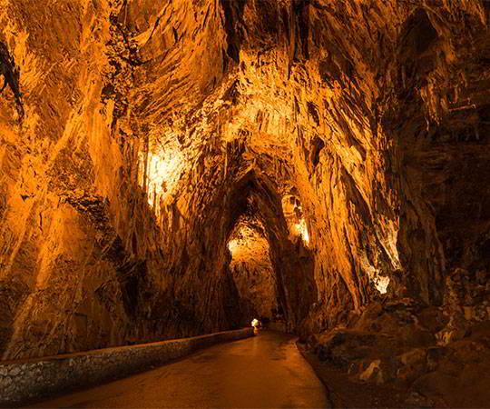 Image of the interior of the Cueves Cave with the road inside illuminated. Council of Ribadesella.