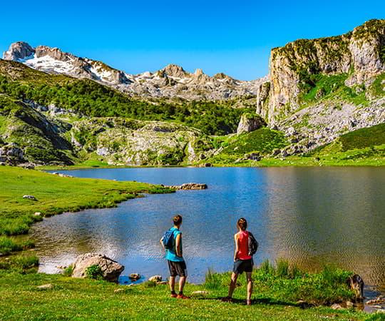 Imagen del Lago Ercina en el concejo de Cangas de Onís con dos personas en primer plano observando el lago.